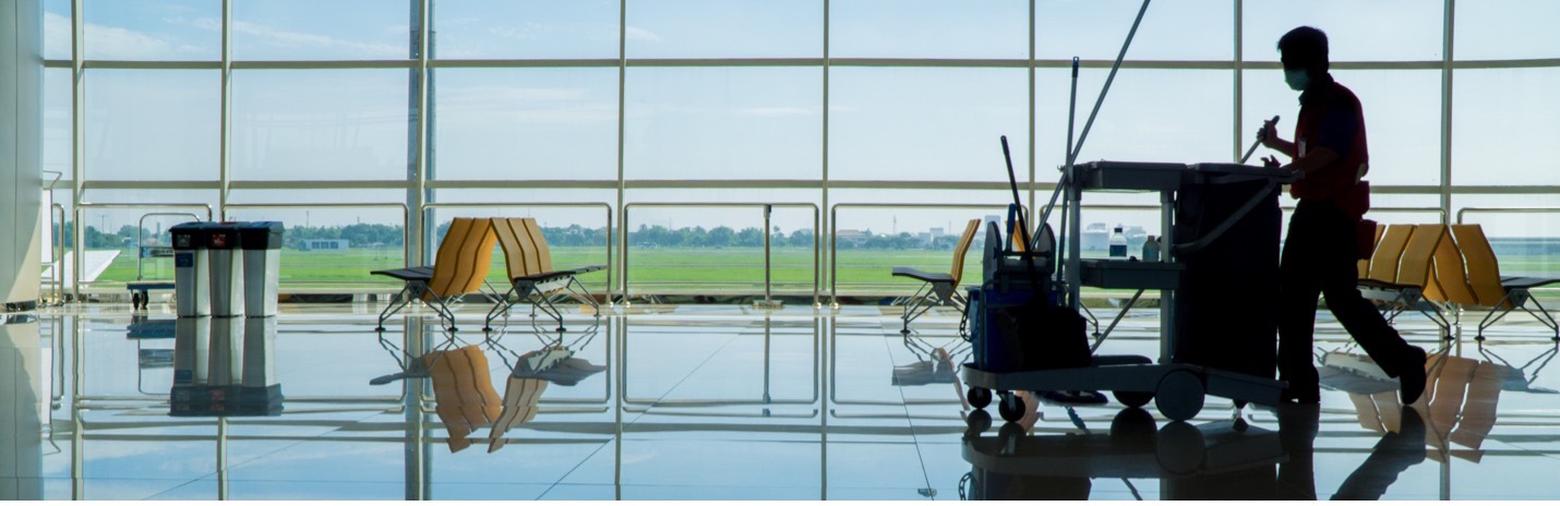 Custodial person walking through airport terminal